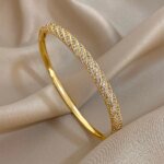 Lyxigt Vridet Manschettarmband i Guld med Zirkoner